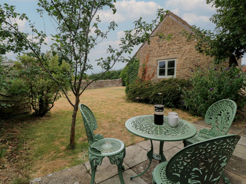 A garden with a table and chairs at The Lodge at Mortons in Hankerton