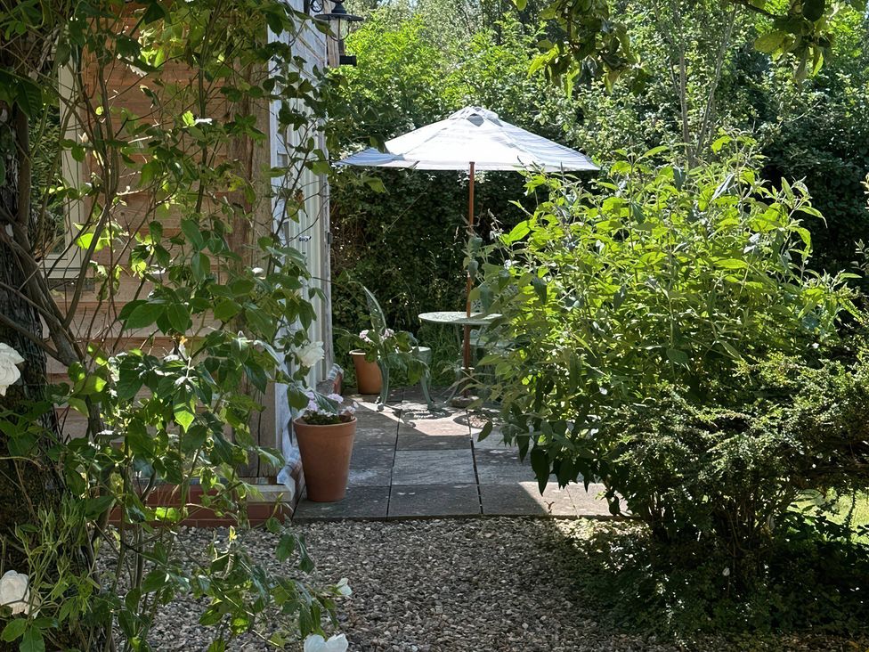 A garden area with a table and umbrella at The Lodge at Mortons in Hankerton