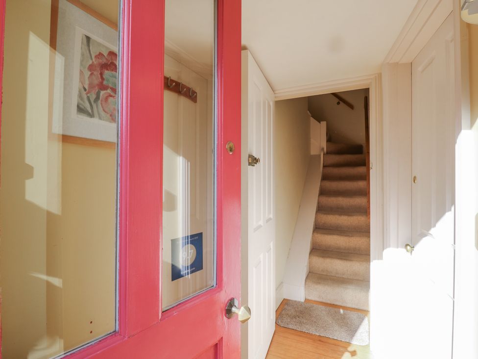 An entrance hallway with a staircase and open door at Over Village Studio in Over