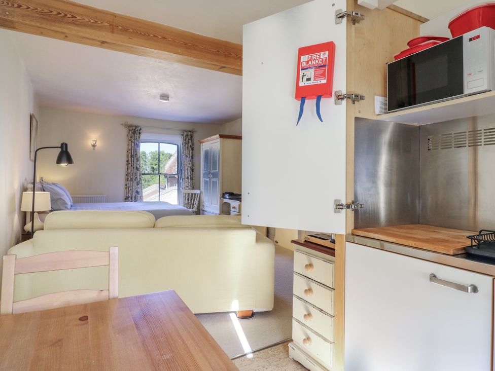 A studio with a sofa and kitchenette at Over Village Studio in Over