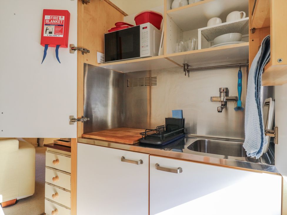 A kitchen with a microwave and sink at Over Village Studio in Over
