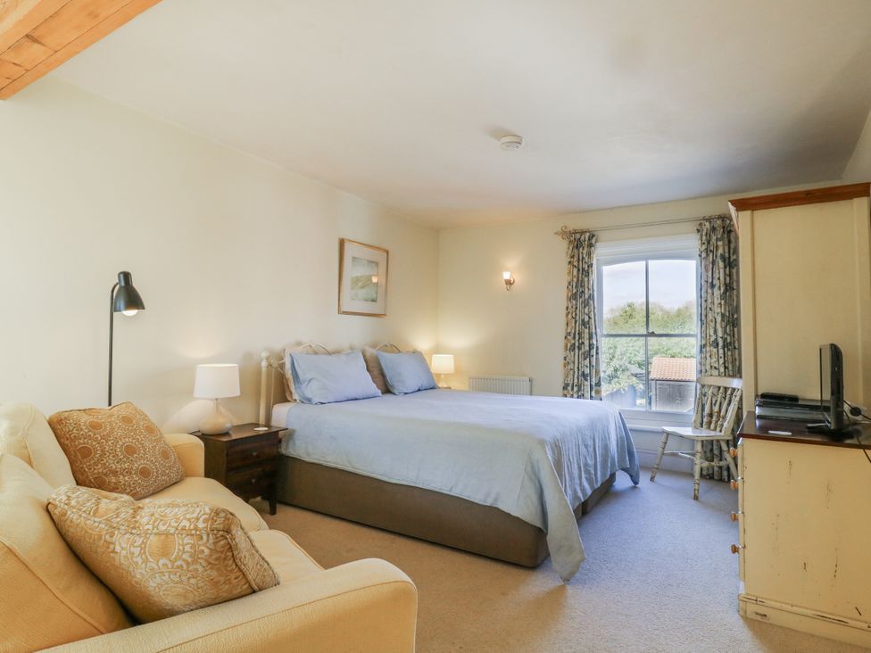 A bedroom with a bed and sofa at Over Village Studio in Over