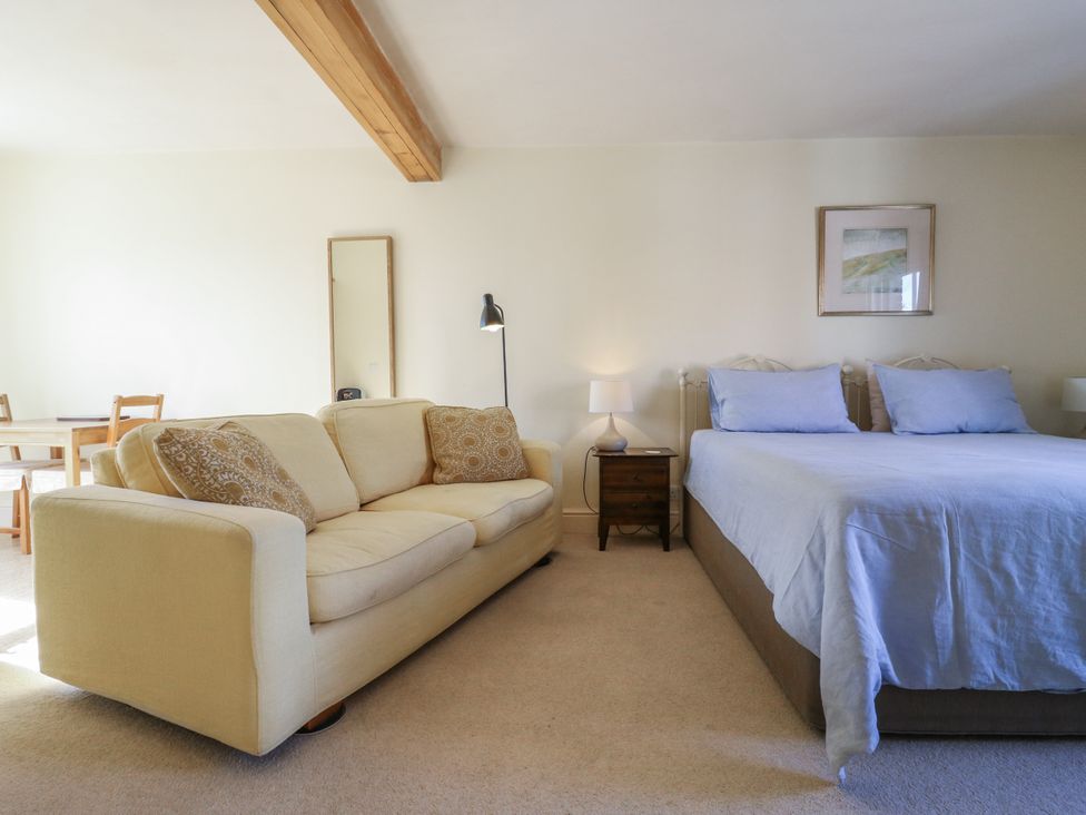 A living room with a sofa and bed at Over Village Studio in Over