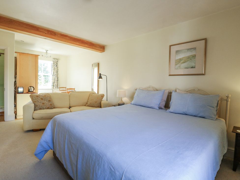 A bedroom with a bed and sofa at Over Village Studio in Over