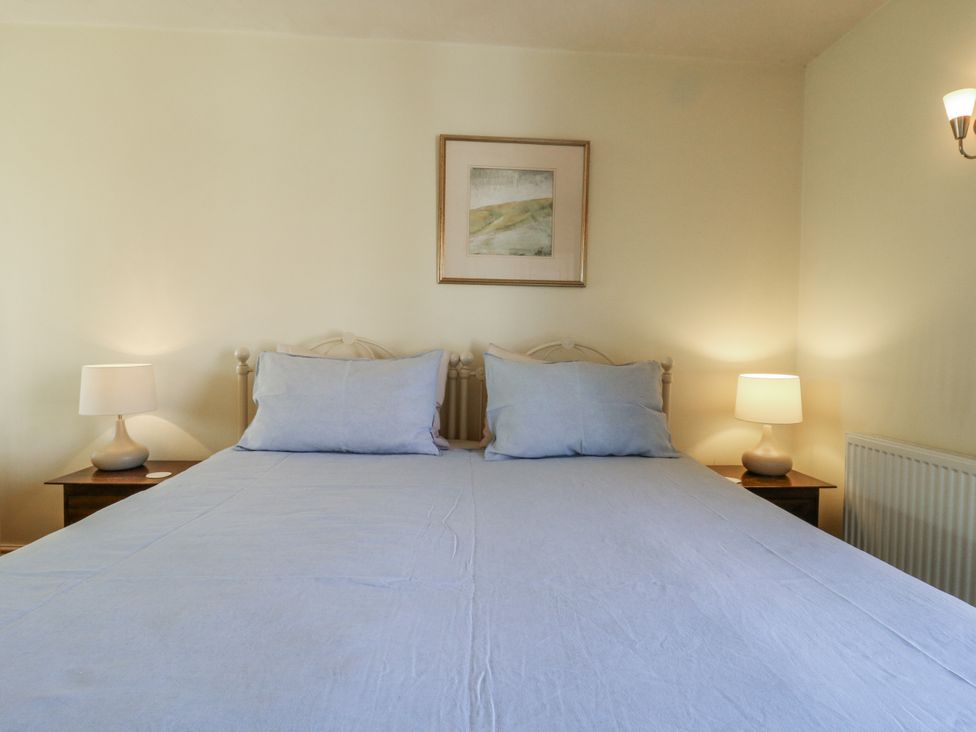 A bedroom with a large bed and bedside lamps at Over Village Studio in Over