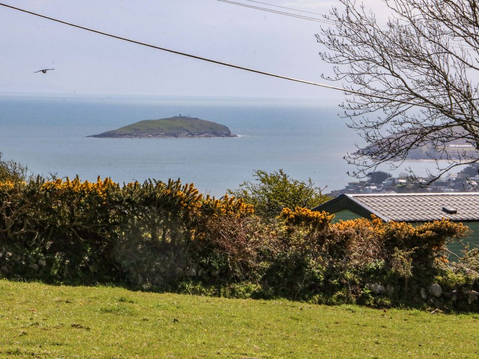 A coastal view with an island in the sea at Pen Y Garth Mynytho near Llanbedrog