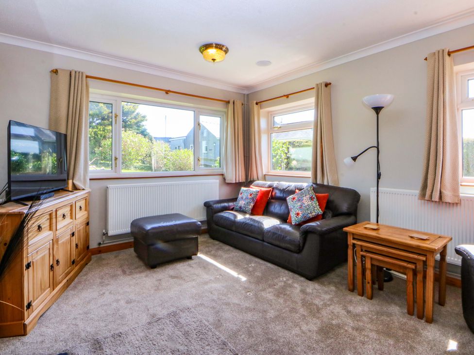 A living room with a sofa and television at Pen Y Garth Mynytho near Llanbedrog