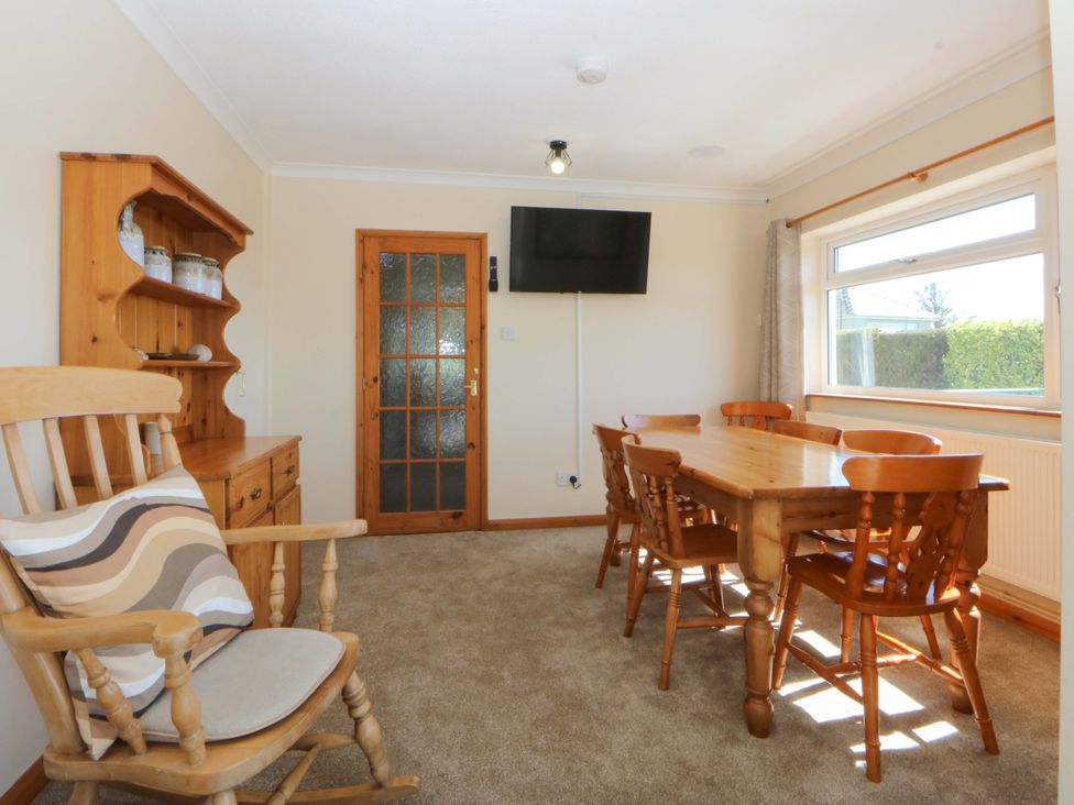 A dining room with a table and chairs at Pen Y Garth in Mynytho near Llanbedrog