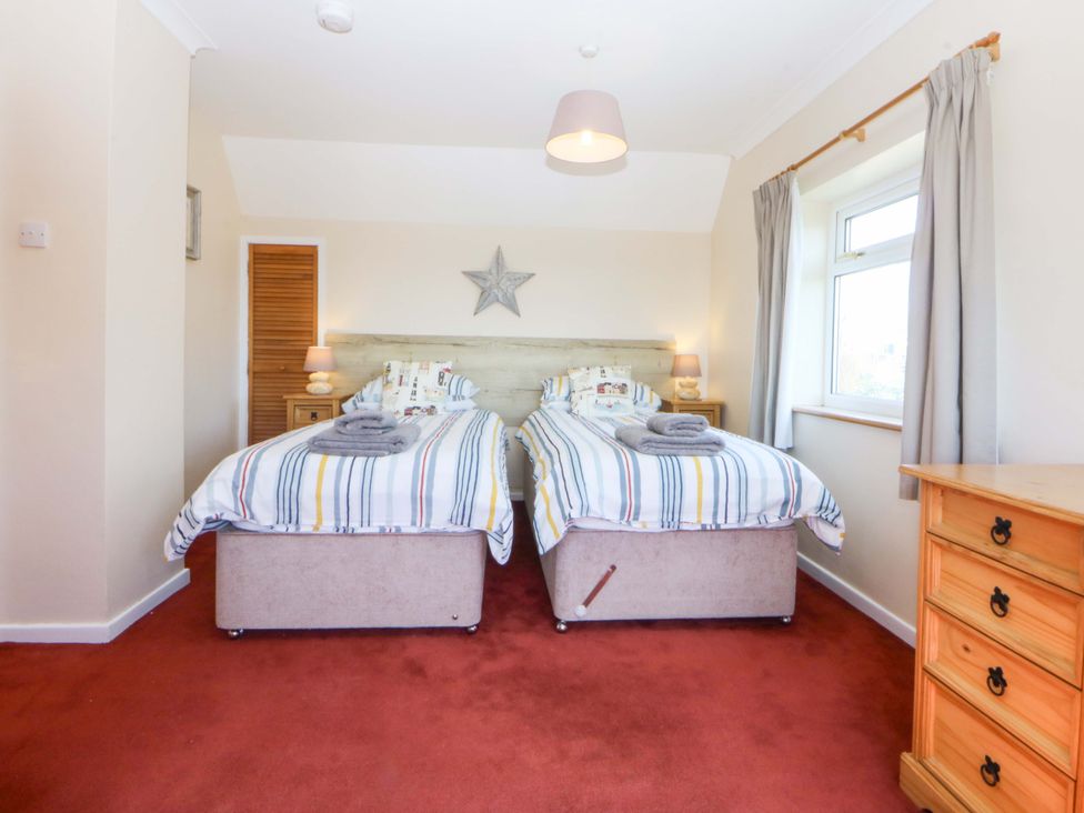 A bedroom with two beds and a chest of drawers at Pen Y Garth in Mynytho near Llanbedrog