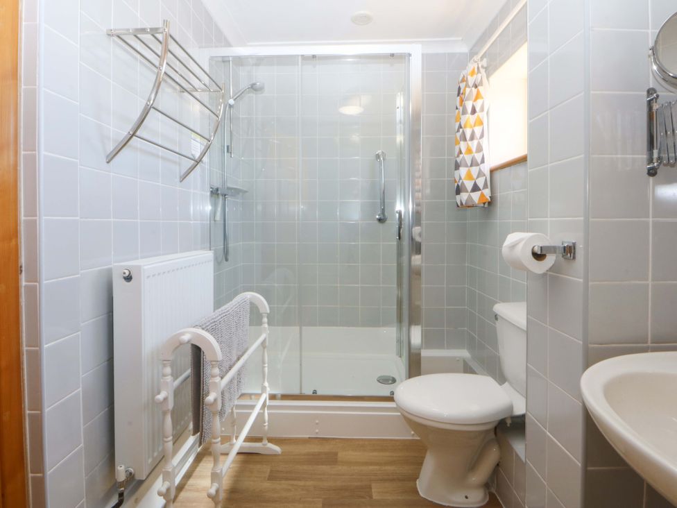 A bathroom with shower, toilet, sink and radiator at Pen Y Garth in Mynytho near Llanbedrog