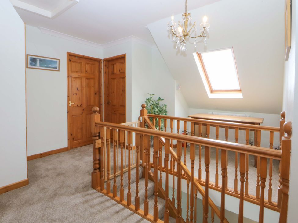 A hallway with a staircase and doors at Pen Y Garth in Mynytho near Llanbedrog