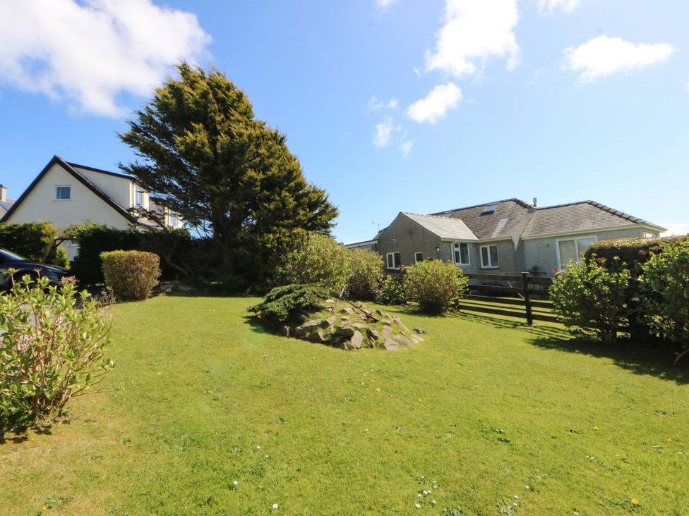 A garden with a house and tree at Pen Y Garth in Mynytho near Llanbedrog