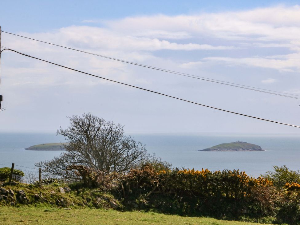 A view of two islands in the ocean with trees and a fence in the foreground at Pen Y Garth Mynytho near Llanbedrog