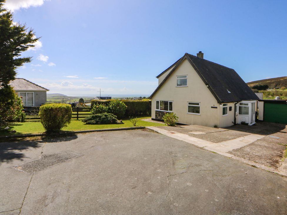 A house with a garage and driveway at Pen Y Garth in Mynytho near Llanbedrog