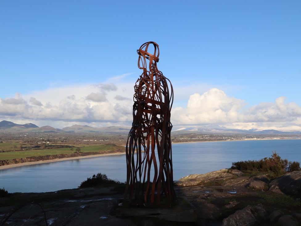 A sculpture overlooking water and mountains at Pen Y Garth in Mynytho near Llanbedrog