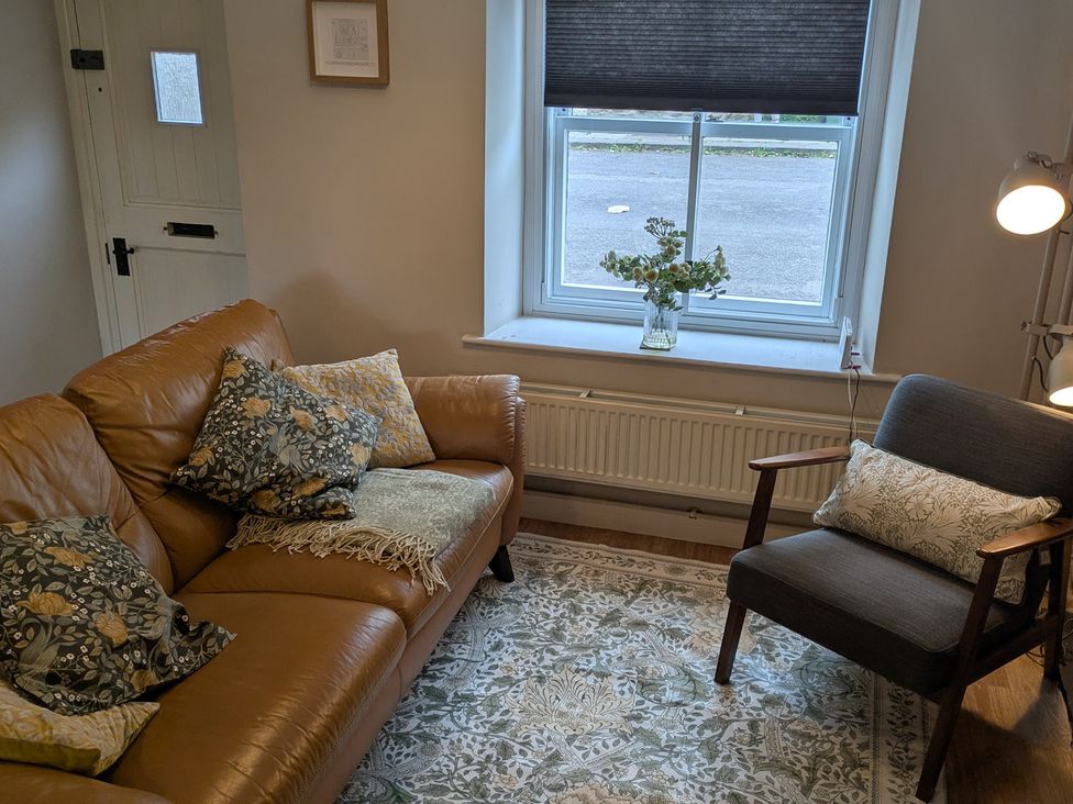 A living room with a sofa and chair at Troopers Cottage in Frome