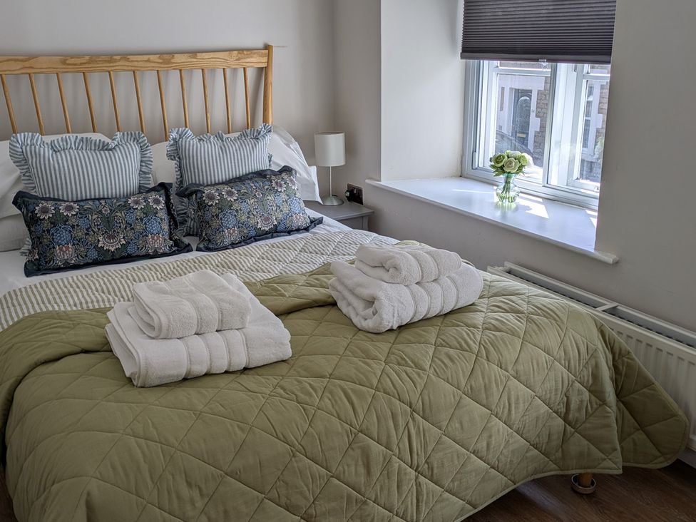 A bedroom with a bed and pillows at Troopers Cottage in Frome