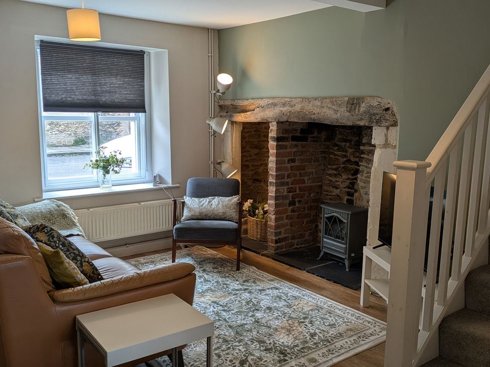 A living room with a sofa and fireplace at Troopers Cottage in Frome