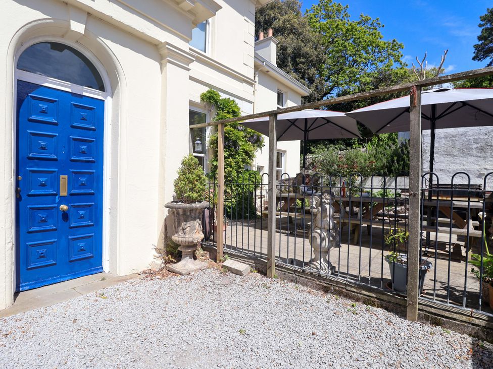 An outdoor area with a blue door and patio furniture at Holcombe House in Torquay