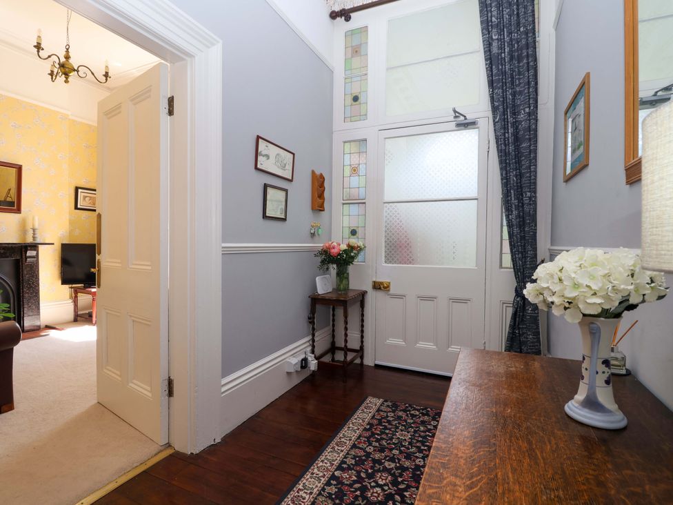 A hallway with a table and flowers at Holcombe House in Torquay