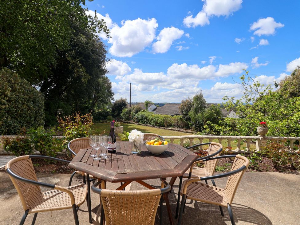 An outdoor seating area with a table and chairs at Holcombe House in Torquay