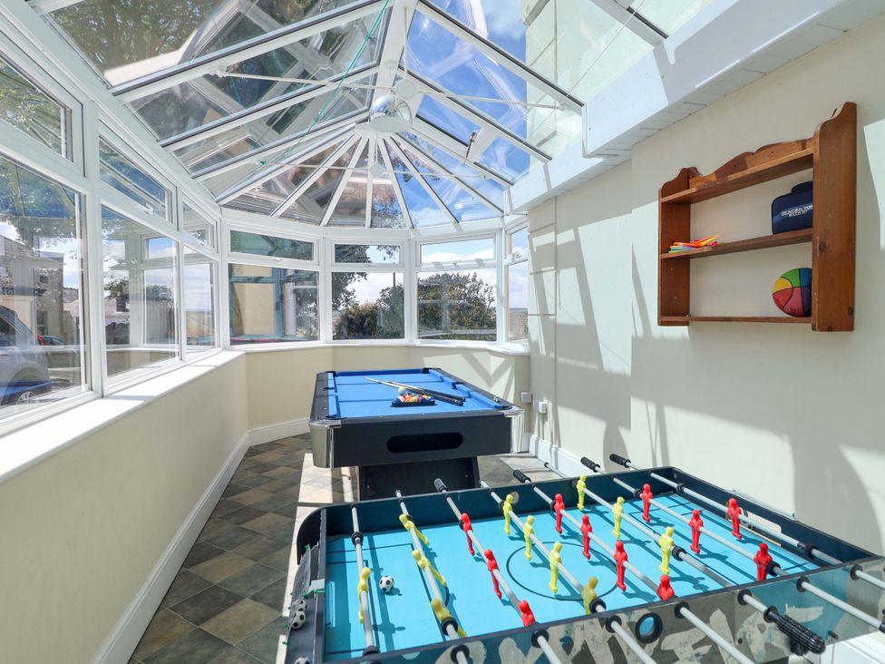 A conservatory with a pool table and foosball table at Holcombe House in Torquay