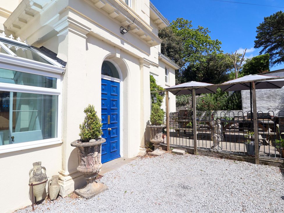 An outdoor area with gravel and a blue door at Holcombe House in Torquay
