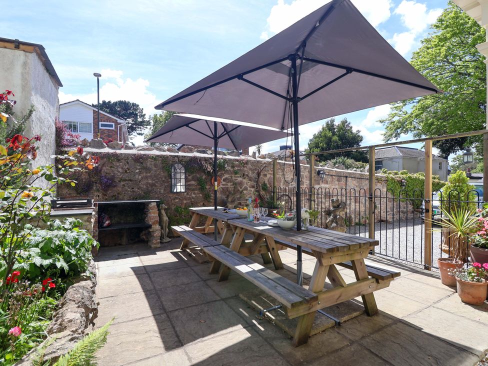 An outdoor seating area with a table and benches at Holcombe House in Torquay