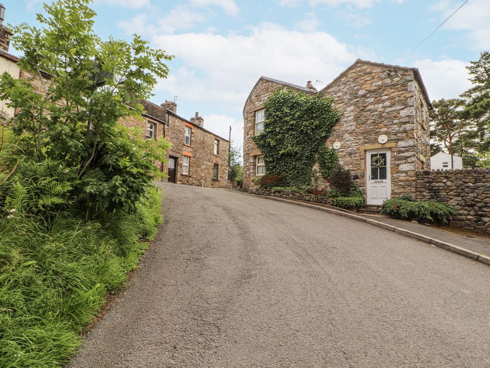 A street with stone buildings and greenery at Corner Cottage Ingleton