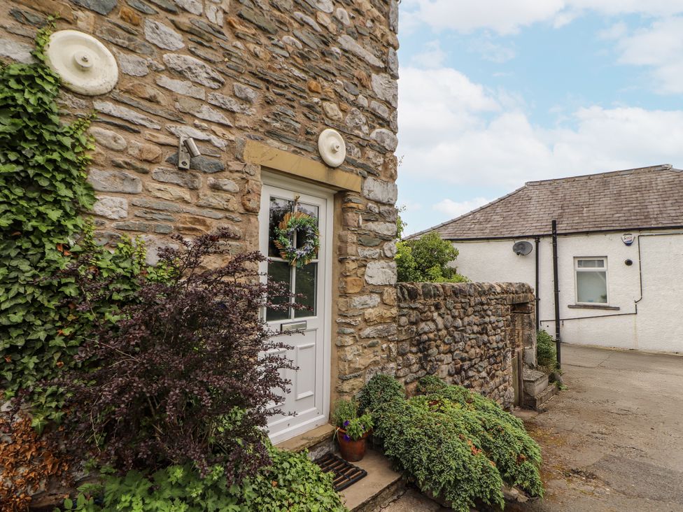 A door with a wreath outside a stone building at Corner Cottage Ingleton