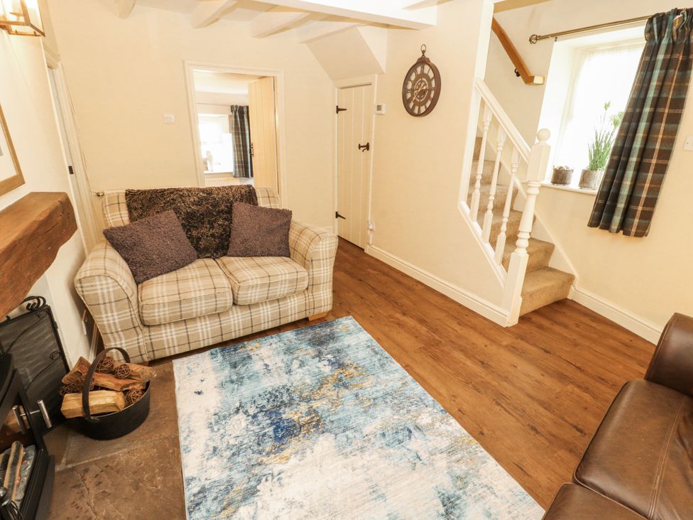 A living room with a sofa and a rug at Corner Cottage in Ingleton