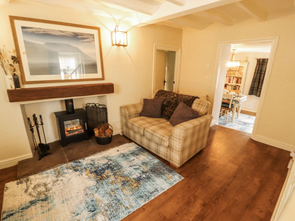 A living room with a sofa and fireplace at Corner Cottage Ingleton