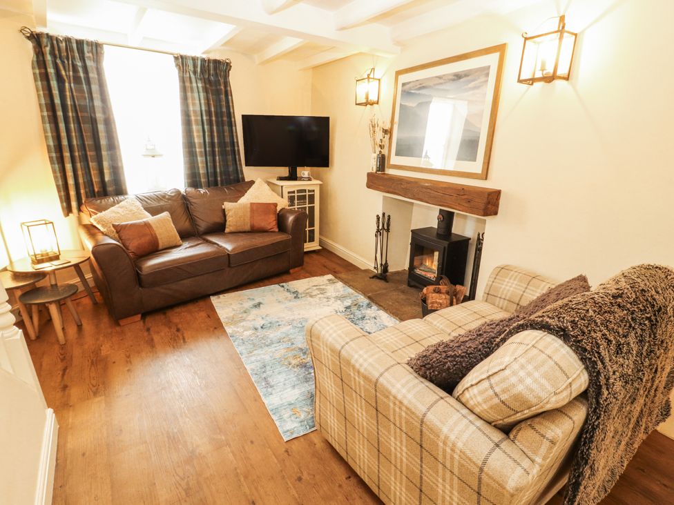 A living room with a sofa and TV at Corner Cottage Ingleton