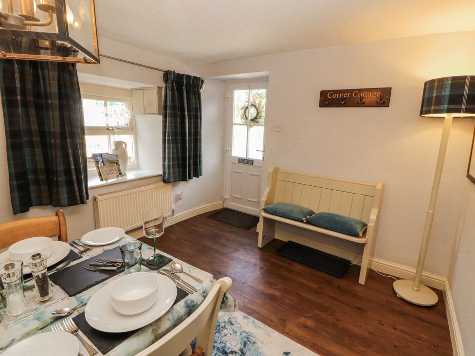 A dining room with a table set for meals at Corner Cottage Ingleton