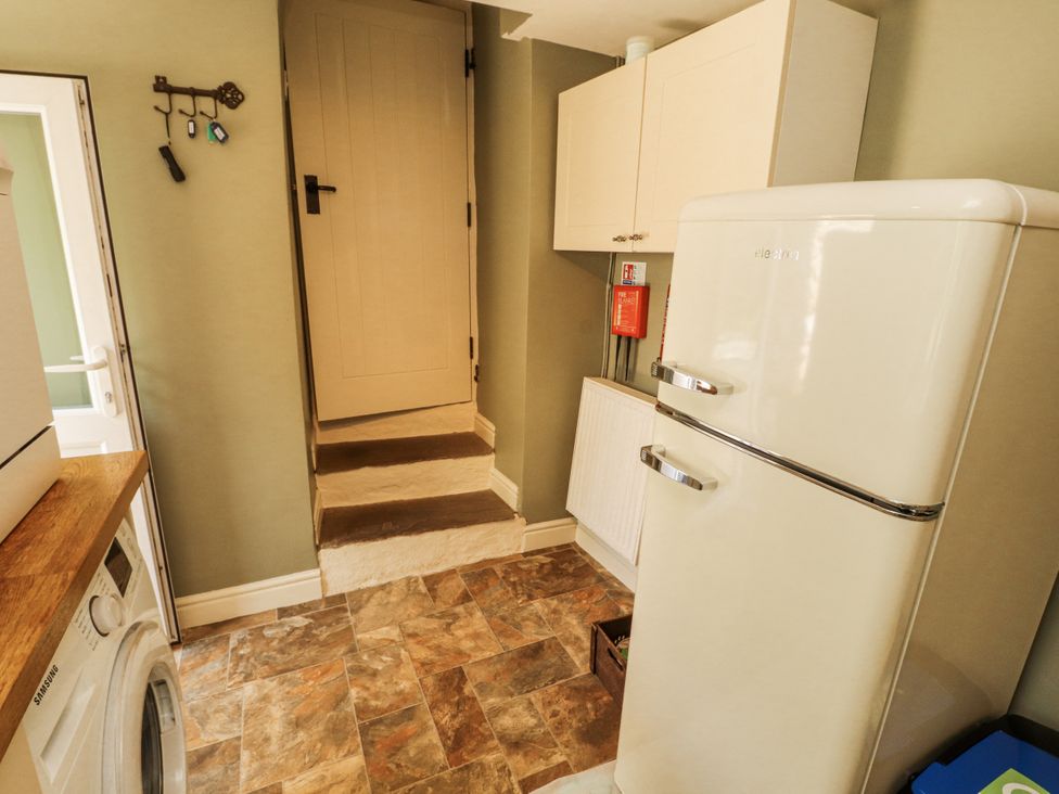 A utility room with a fridge and washing machine at Corner Cottage Ingleton
