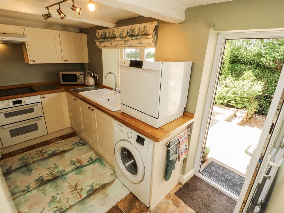 A kitchen with appliances and a door leading outside at Corner Cottage Ingleton