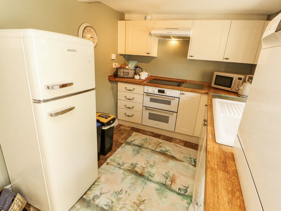 A kitchen with a fridge and oven at Corner Cottage Ingleton