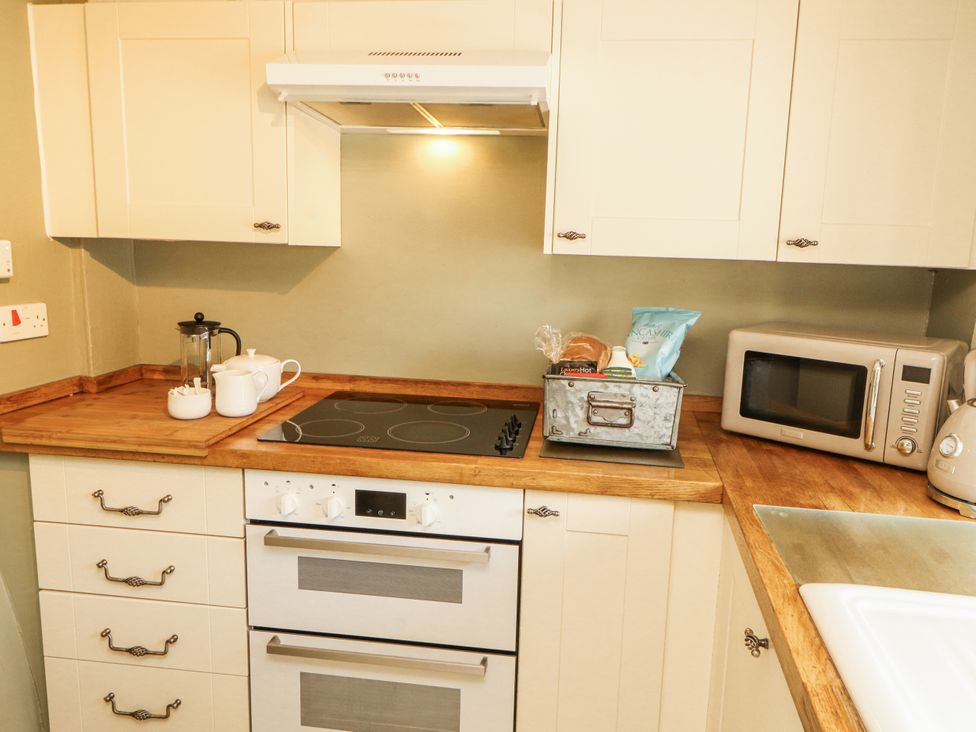 A kitchen with stove and microwave at Corner Cottage Ingleton