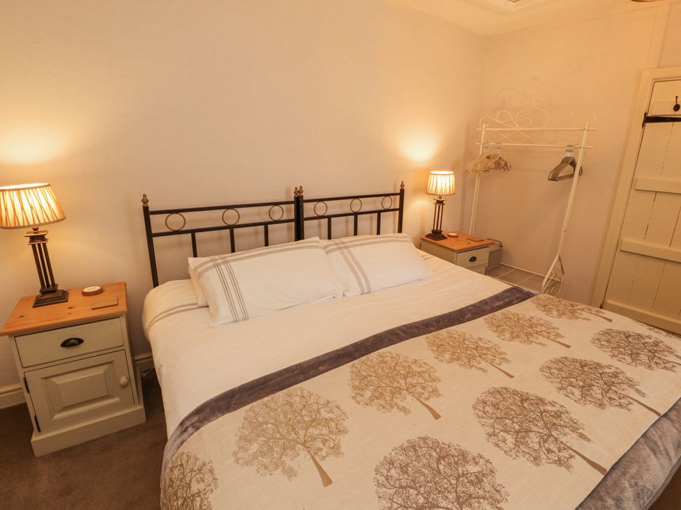 A bedroom with a bed and bedside tables at Corner Cottage Ingleton