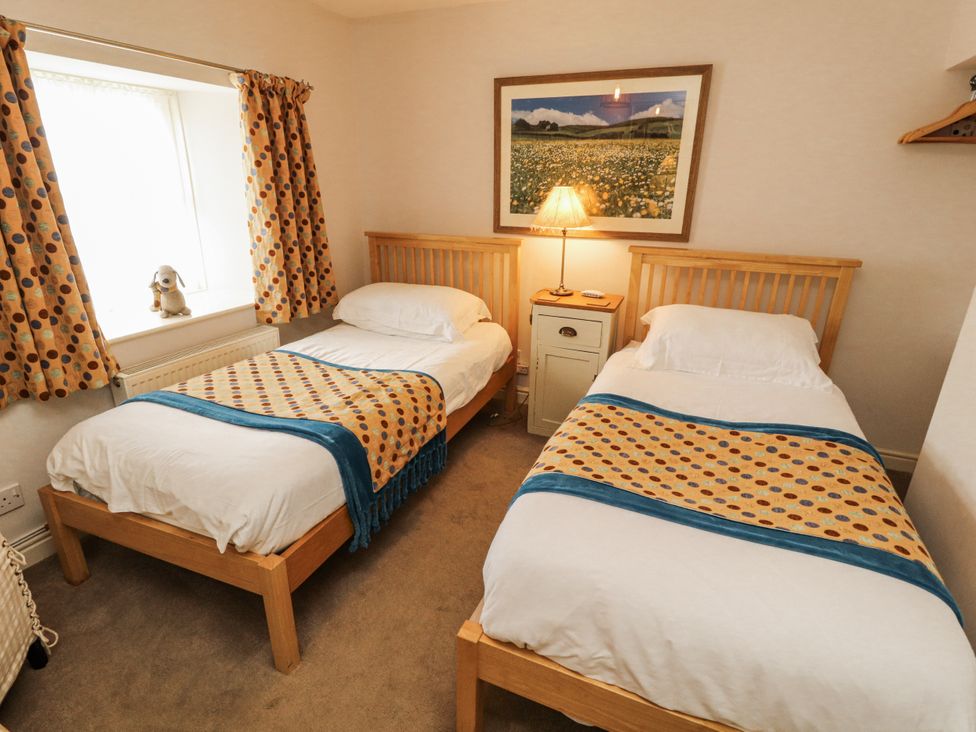 A bedroom with two single beds and a lamp at Corner Cottage Ingleton