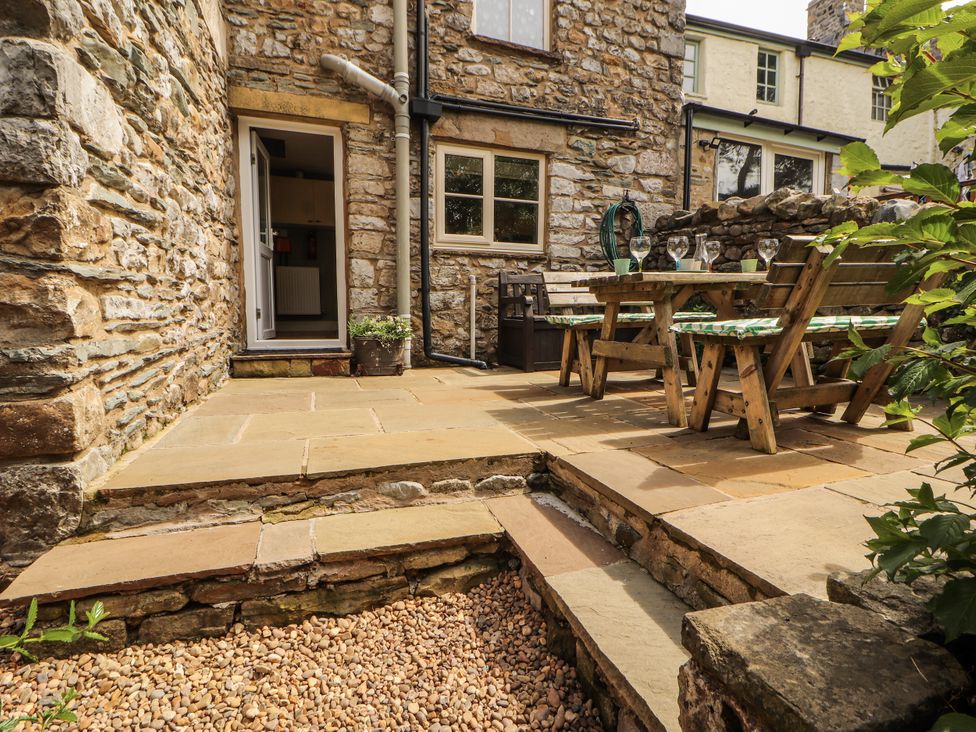 An outdoor patio area with a table and chairs at Corner Cottage Ingleton