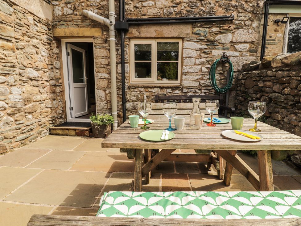 An outdoor dining area with a table and chairs at Corner Cottage Ingleton