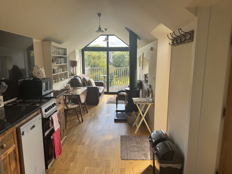 A kitchen with a sofa and dining area at The Hideout in Llangrove