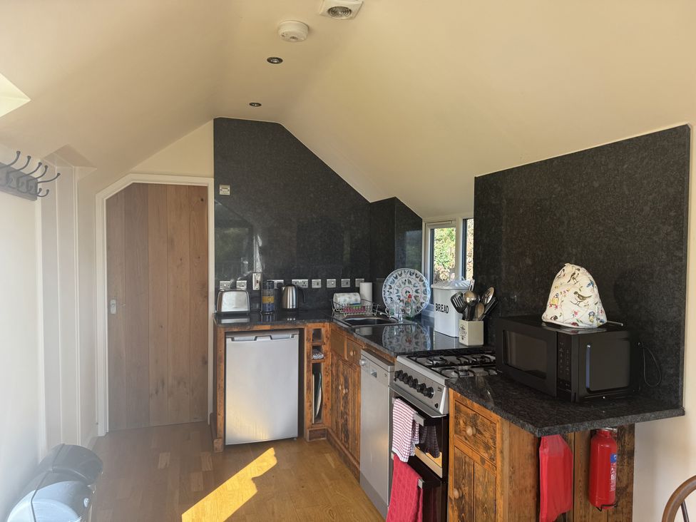 A kitchen with appliances and cabinets at The Hideout in Llangrove