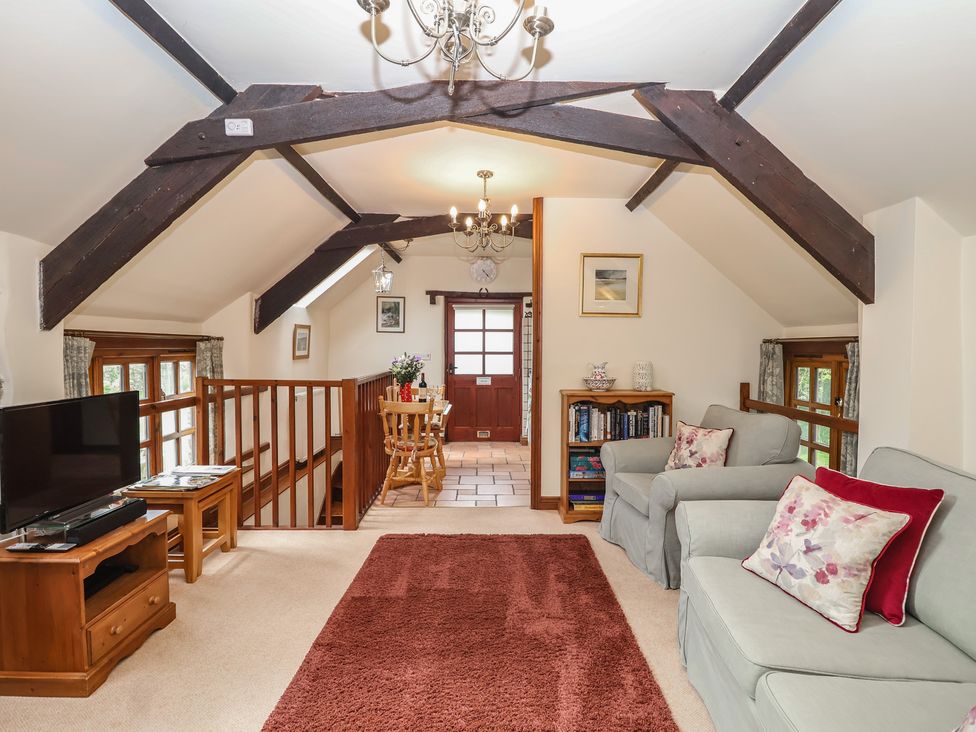A living room with a television and sofa at The Coach House in Kingston