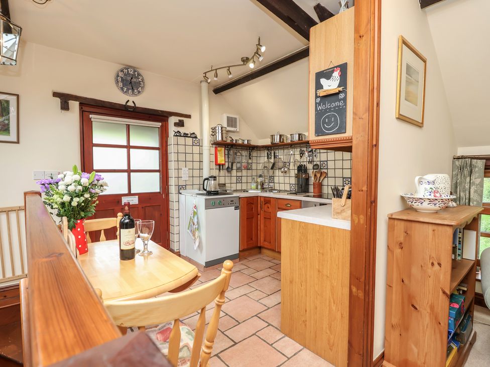 A kitchen with a wooden table and chairs at The Coach House in Kingston