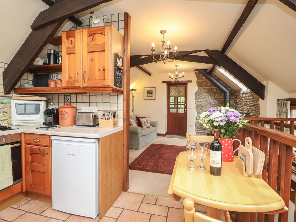 A kitchen with wooden cabinets and appliances at The Coach House in Kingston