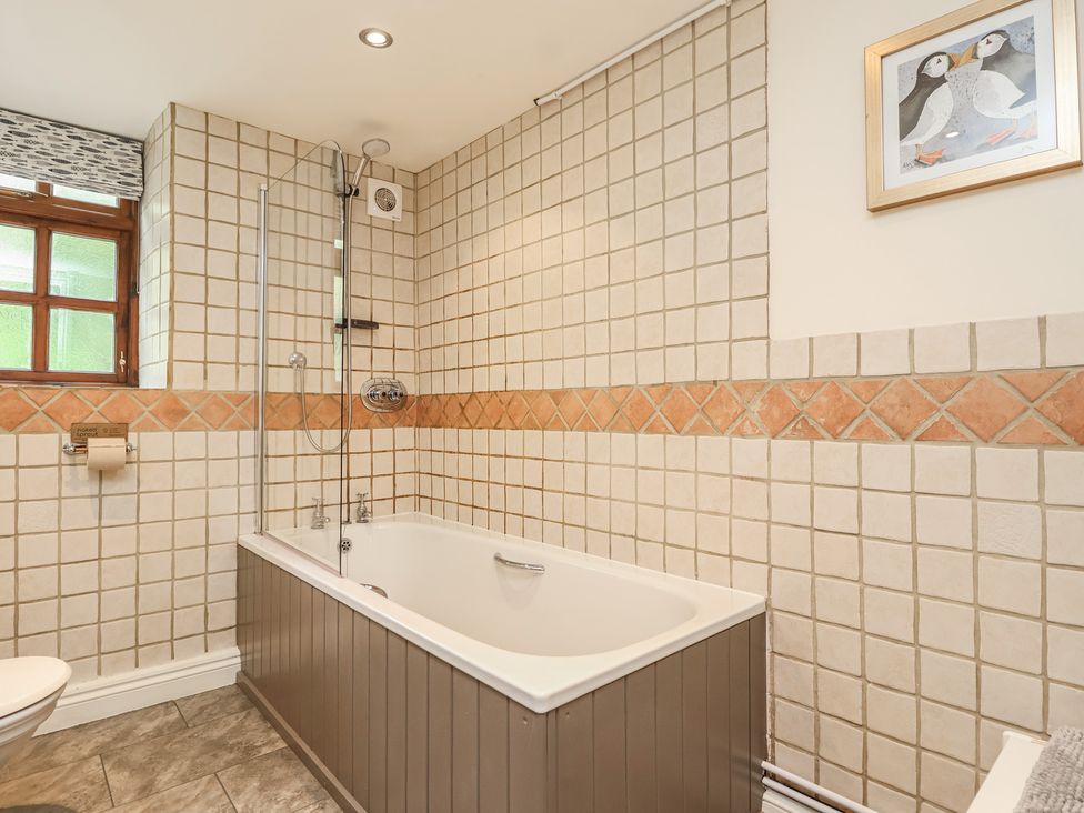 A bathroom with a bathtub and shower at The Coach House in Kingston
