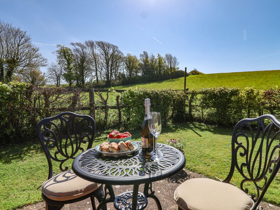 An outdoor seating area with a table and chairs at The Coach House in Kingston