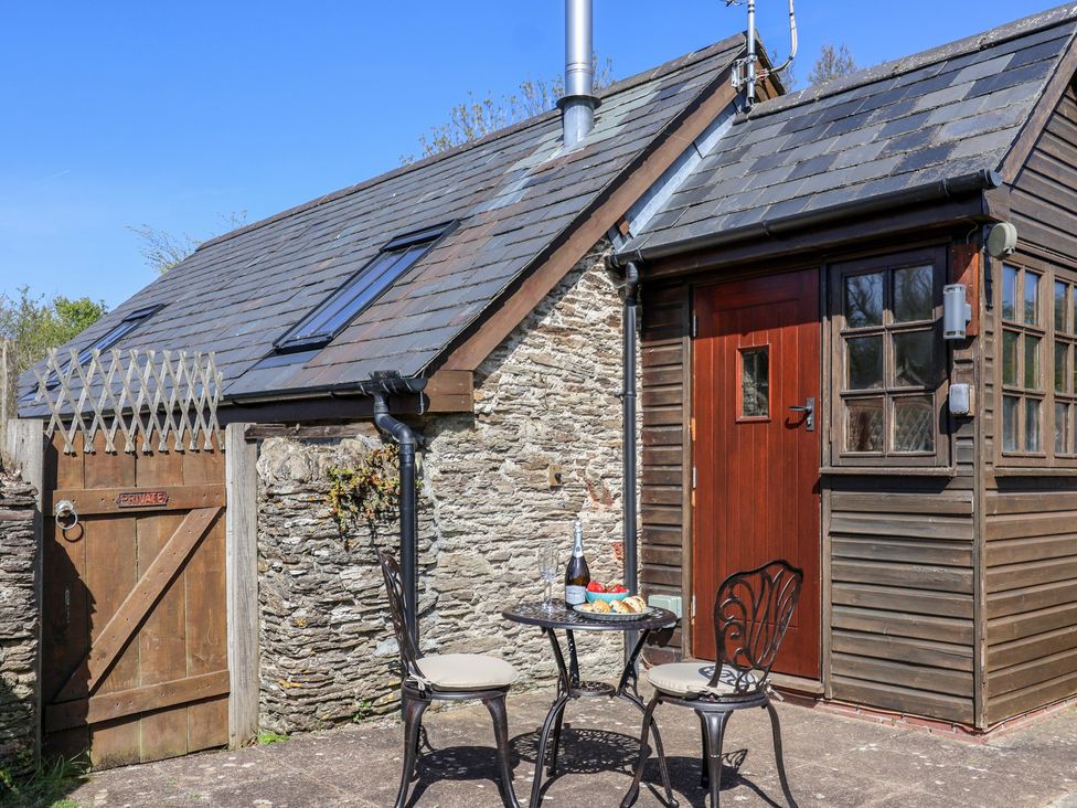 An outdoor seating area with a table and chairs at The Coach House in Kingston